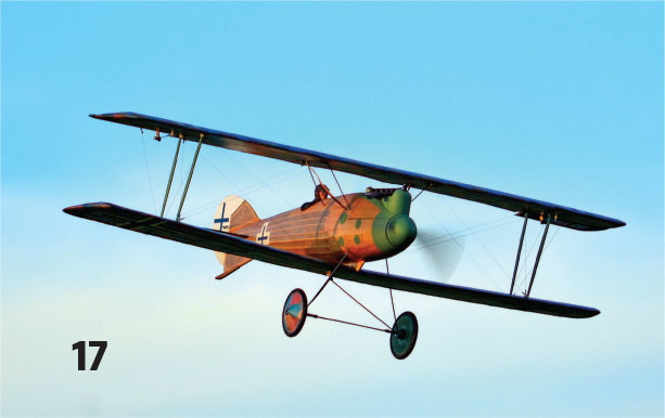 Vintage biplane flying in clear blue sky, number 17 visible.