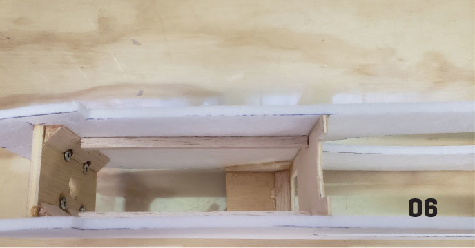 Wooden structure with interior compartments, number "06" in black.