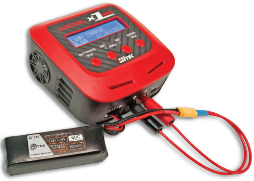 Red battery charger with attached battery and cables.