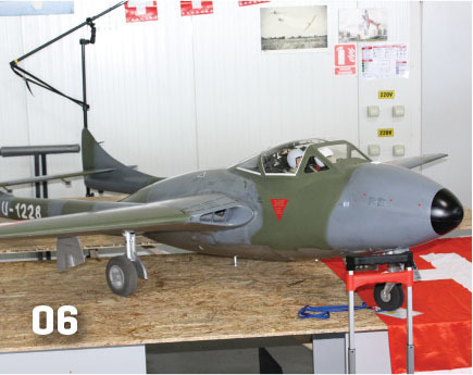 Model jet aircraft on a workbench, marked "06".