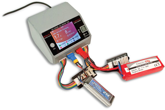 Battery charger connected to batteries, displaying voltage and settings on its screen.