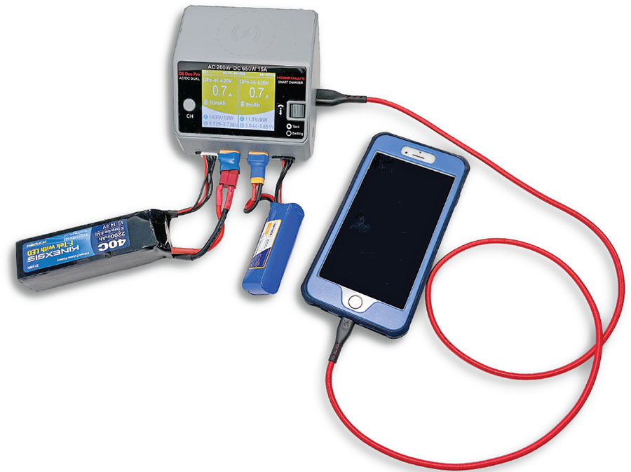 Charger connects to two batteries and a smartphone with red and black cables.