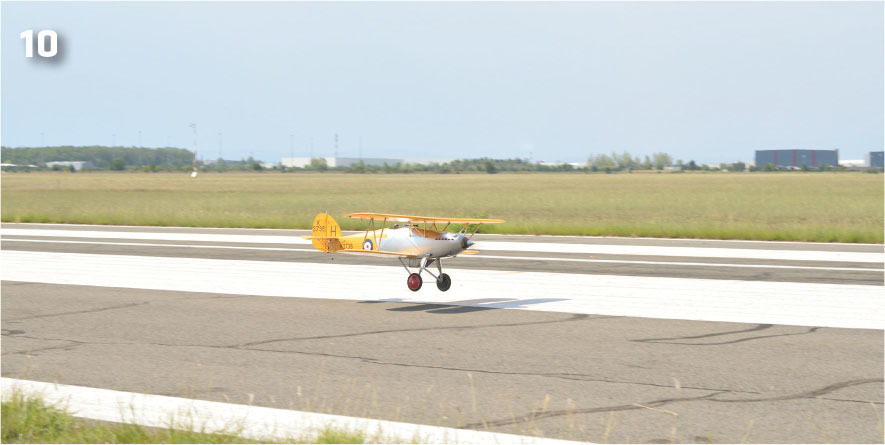 Small vintage plane landing on a runway, number 10 top left.