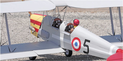 Model biplane with red helmeted pilot, marked with a circle and number 5.