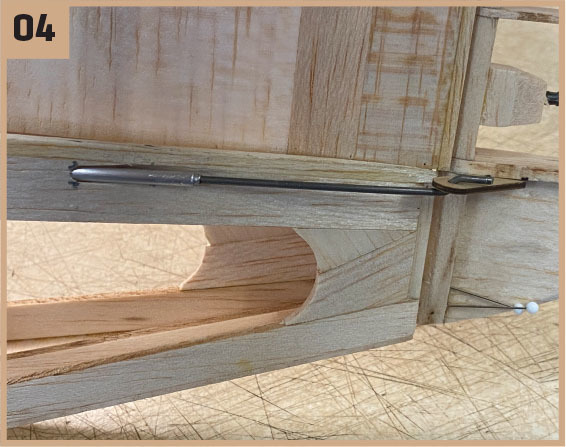 Wooden model with metal rod and pins, number 04 in the corner.