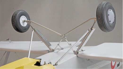 Model airplane landing gear detail with metal struts and small wheels.