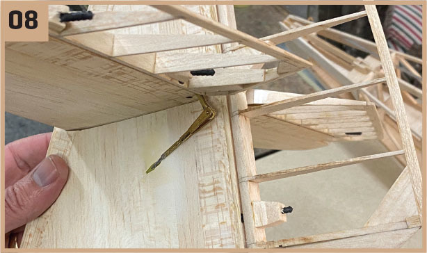 Wooden model airplane under construction, numbered 08.