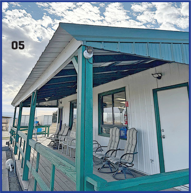 Outdoor porch with chairs, white siding, teal trim, and a cloudy sky. Number 05 on wall.