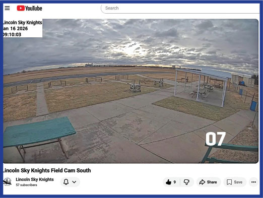 Overcast sky above an empty outdoor field with benches and a shelter.
