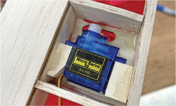 Micro servo motor SG90 in wooden frame, blue casing.
