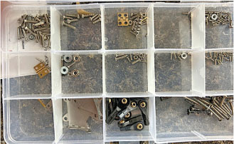 Storage box with various screws, nuts, and small hardware sorted into compartments.