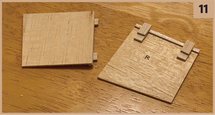 Two wooden squares on a table, one with the letter "R" and small sticks on top.