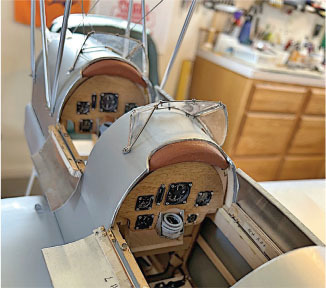 Model biplane cockpit with detailed instrument panels.