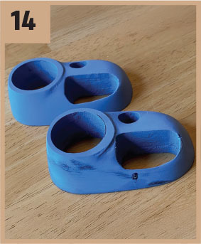 Two blue climbing holds on a wooden surface, marked with "14" in the corner.