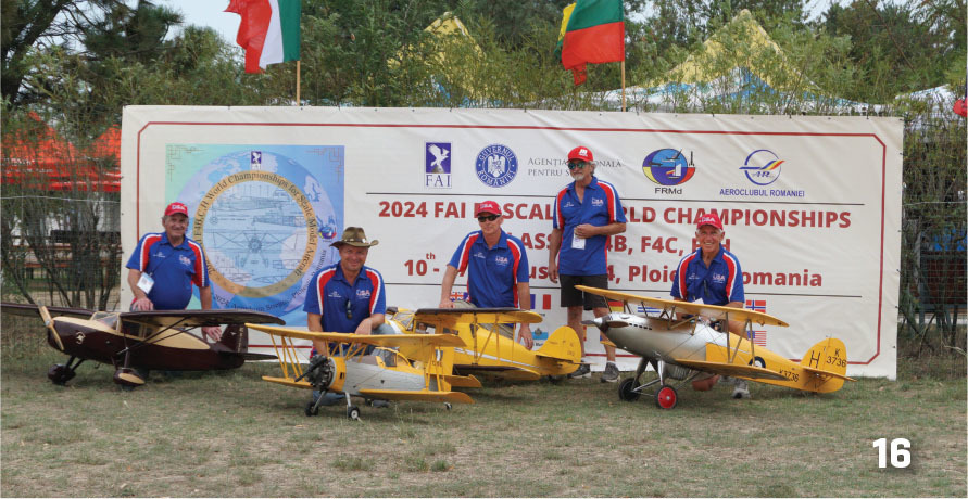 Five men in uniforms with model planes, standing by a championship banner.
