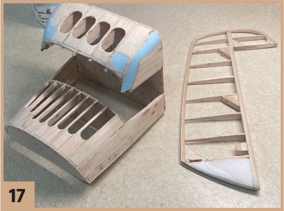 Wooden model aircraft parts on a table, number 17 displayed.