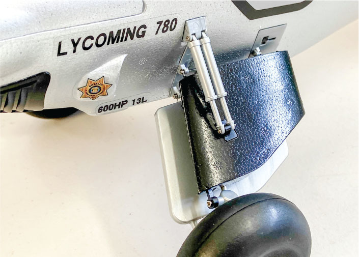 Model plane landing gear, text "LYCOMING 780" and "600HP 13L," star badge visible.