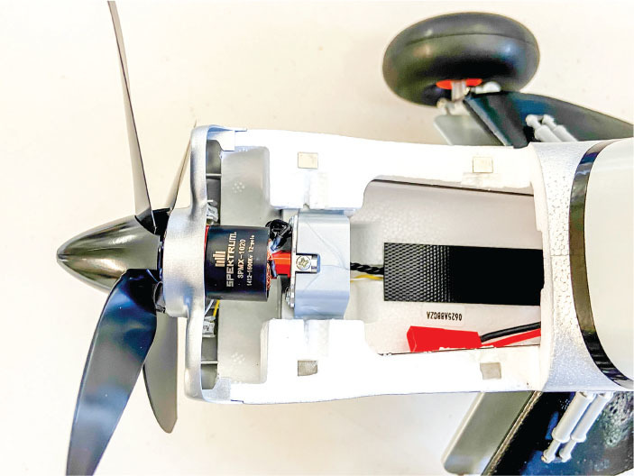 Model airplane motor and propeller assembly with visible wiring.