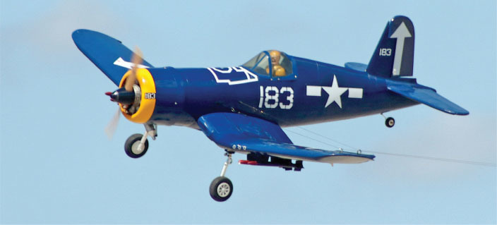 Blue aircraft with yellow nose, white star, and number 183 on side, in flight.