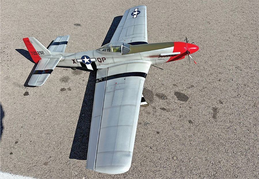 Model airplane resembling a WWII fighter, silver with red nose, star insignia.