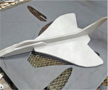 Gray model aircraft on a honeycomb surface.