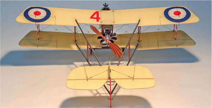 Yellow biplane model with roundels and number 4 on wings, wooden propeller.