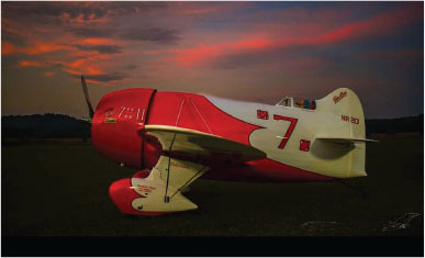 Red and white vintage plane with number 7 at sunset.