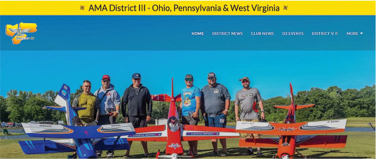 Group of men standing with model planes, AMA District III banner above.