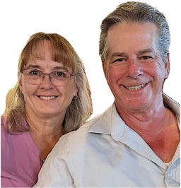 Smiling woman in glasses beside a smiling man with a white shirt.