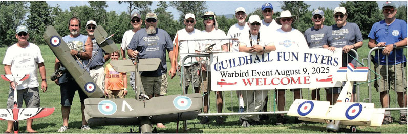 Group of people with model planes and a "Guildhall Fun Flyers" event banner.