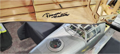 Model airplane with "Prower Master" signature on wooden wing section.