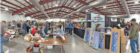 People browsing booths at an indoor market or trade show.