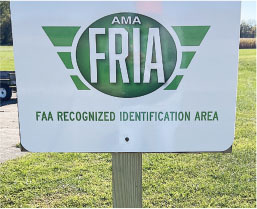 Sign with "AMA FRIA" and "FAA Recognized Identification Area" on grass.