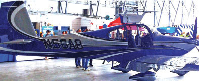 Blue and silver aircraft N56AB in a spacious hangar.