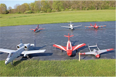 Model airplanes on a grassy field runway.