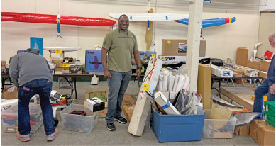 Model airplane sale with people browsing tables of supplies and kits.
