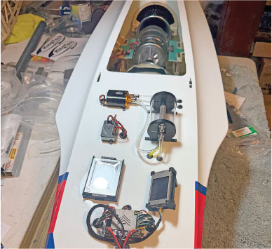 RC aircraft fuselage with visible engine and electronic components.