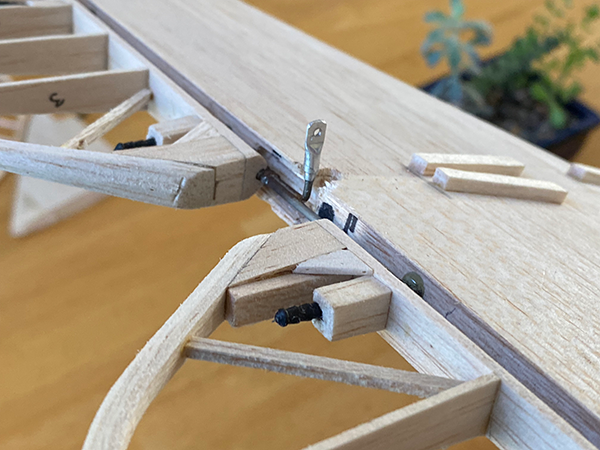 Wooden model plane wing under construction on a table.