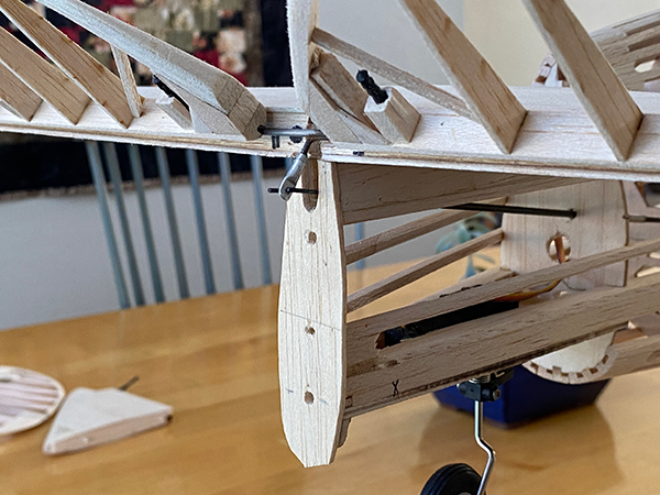 Wooden model airplane under construction on a wooden table.