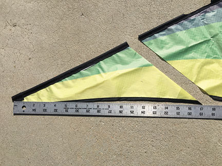Ruler next to colorful triangular fabric pieces on concrete.