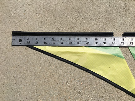 Silver ruler on yellow fabric, measuring in centimeters, on a light concrete surface.