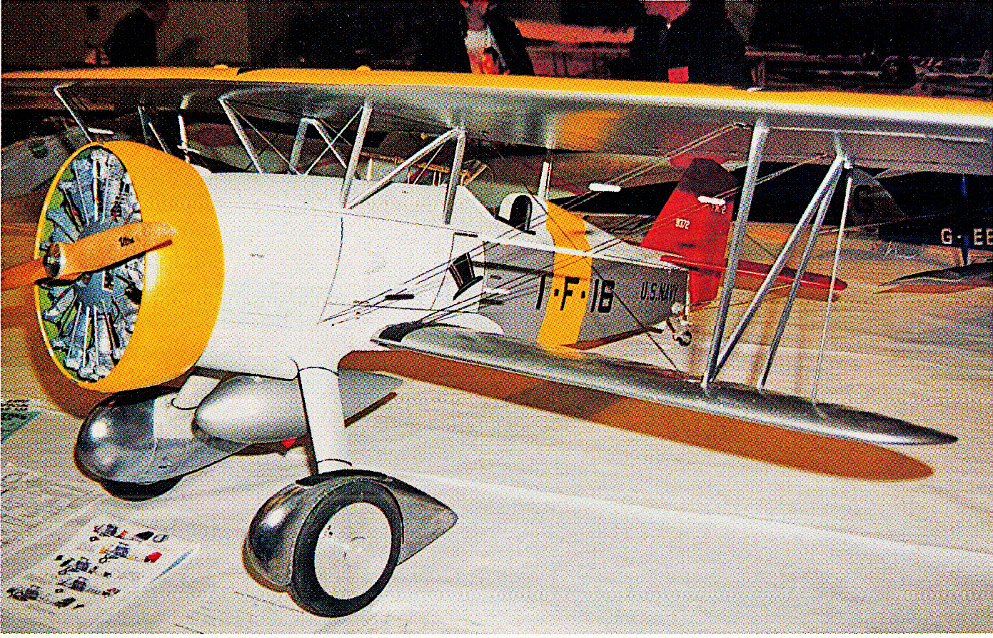 Yellow and silver model biplane displayed on a table.