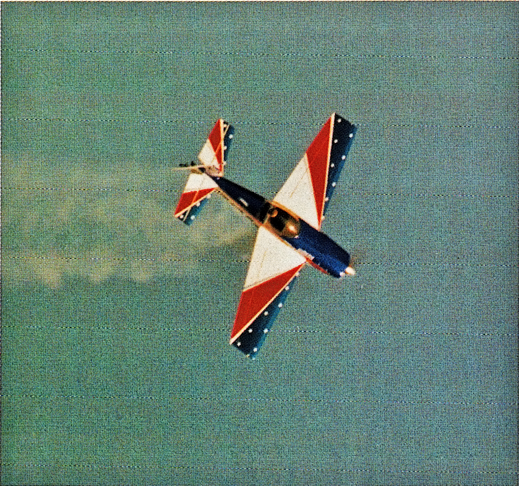 Aerobatic plane against blue sky with red, white, and blue markings.