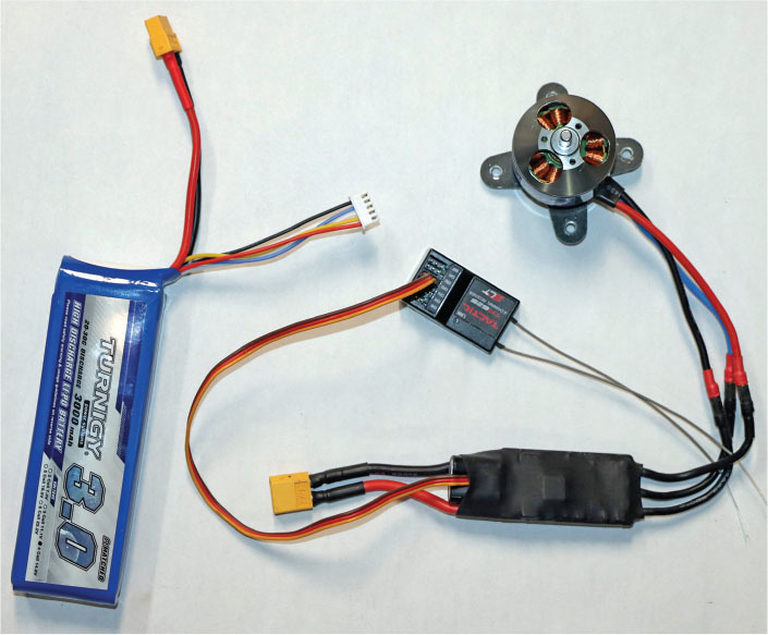 Battery, wiring, and small motor against white background.