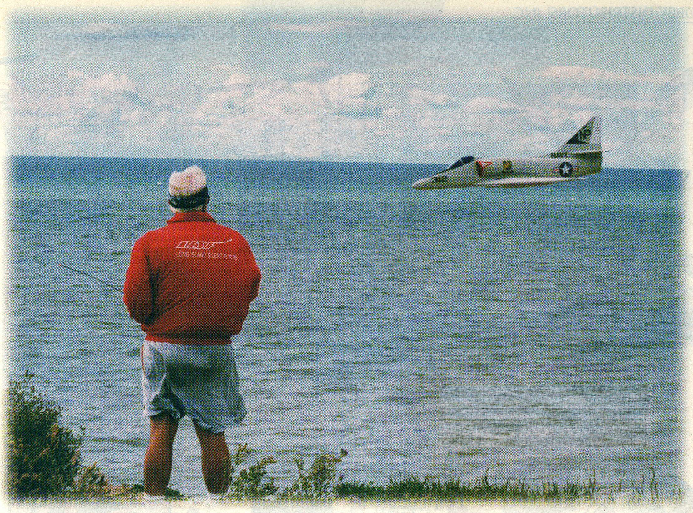 Man flying rc by the sea with a rc jet.