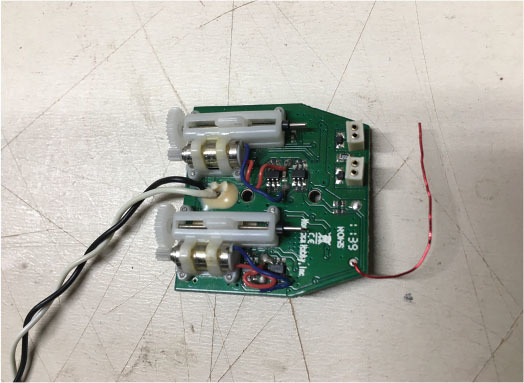 Circuit board with wires on a white surface.