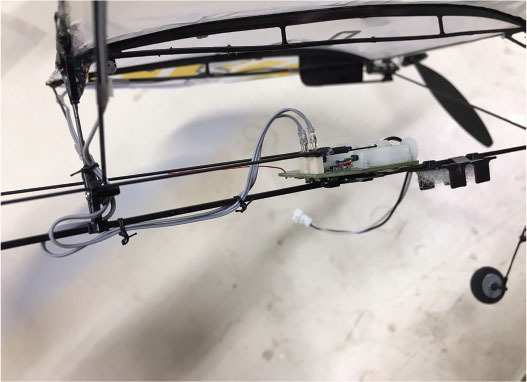 Remote-controlled plane propeller and wiring on a white surface.