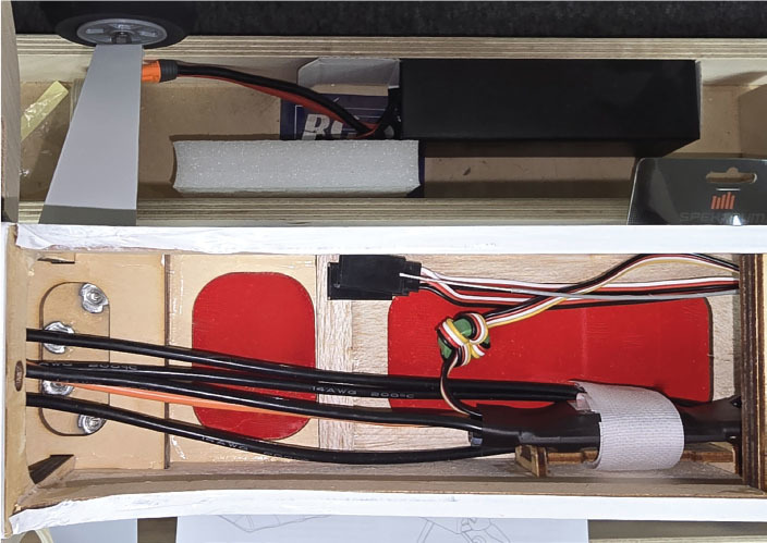 Remote control aircraft electronics with wiring and components inside a wooden frame.