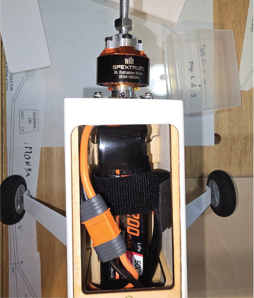 Model airplane fuselage with visible battery and motor.