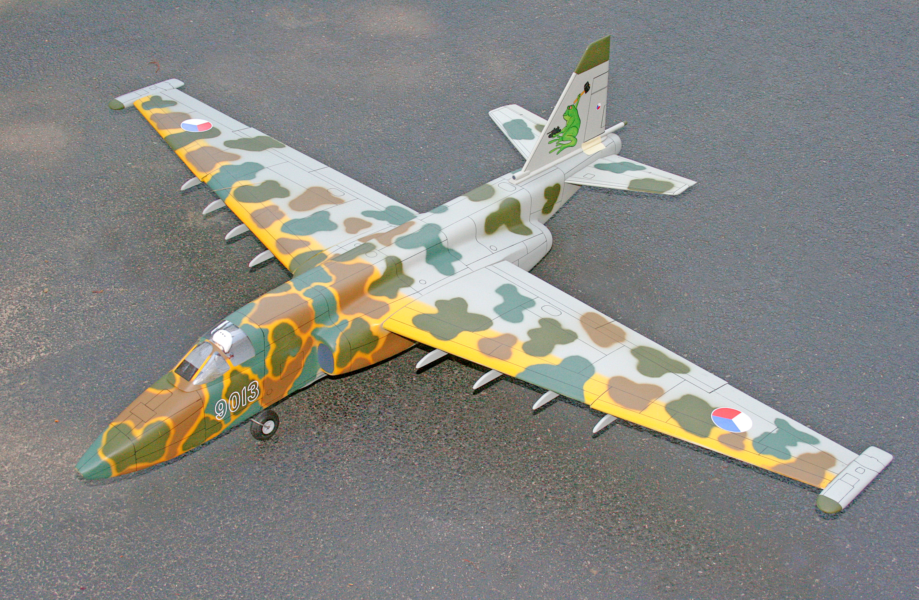 Camouflage-painted model jet on a gray surface.